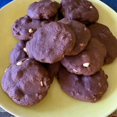 Fudgy chocolate brownie cookies with white chocolate chips stacked on a pale yellow plate, perfect for an easy dessert or sweet snack.
