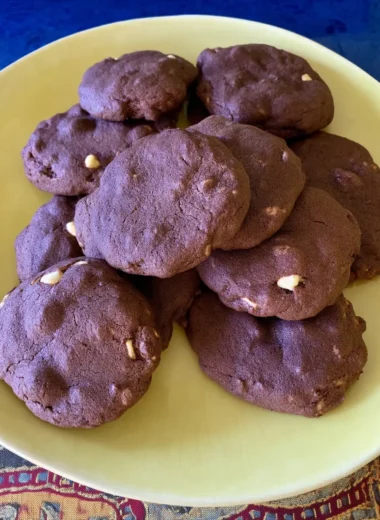 Fudgy chocolate brownie cookies with white chocolate chips stacked on a pale yellow plate, perfect for an easy dessert or sweet snack.