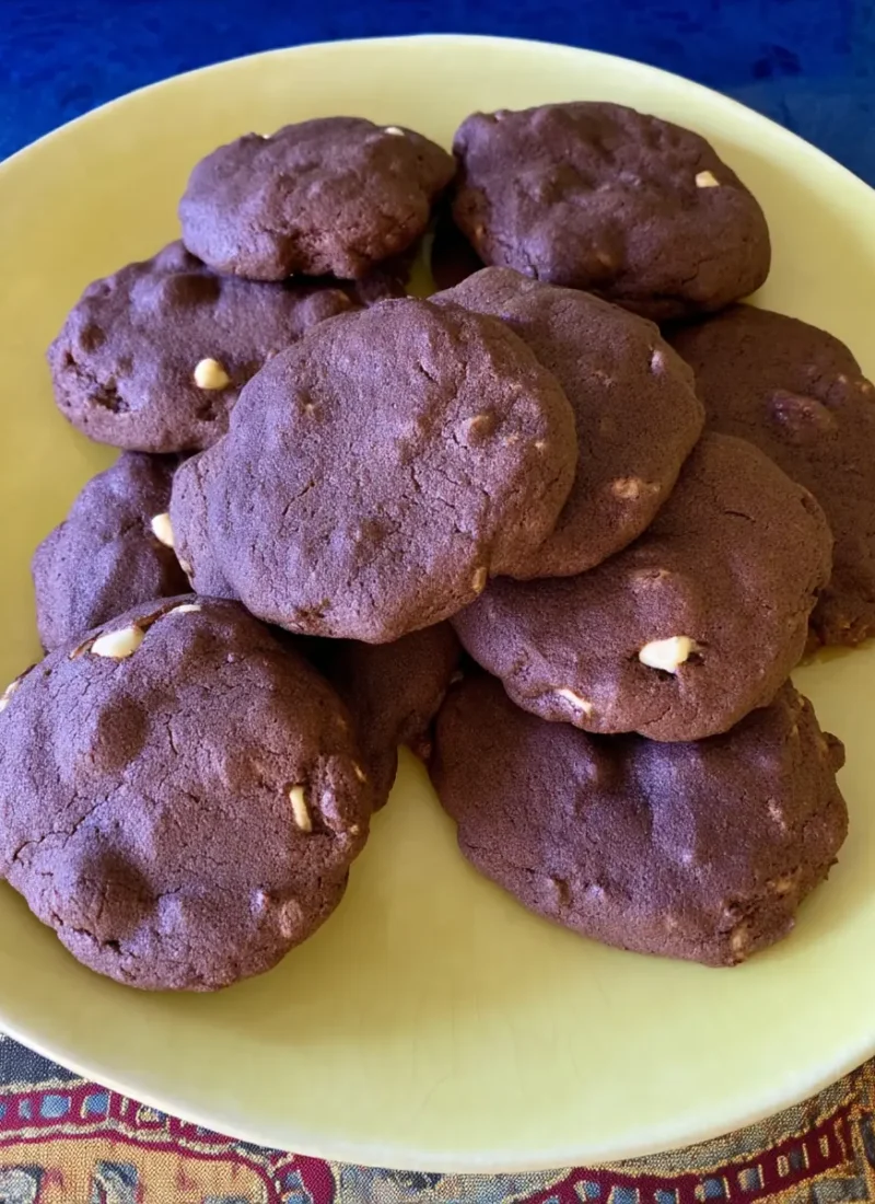 Fudgy chocolate brownie cookies with white chocolate chips stacked on a pale yellow plate, perfect for an easy dessert or sweet snack.