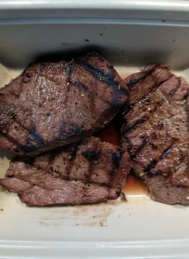 Grilled beef sirloin steak bites with dark char marks resting in their savory juices.